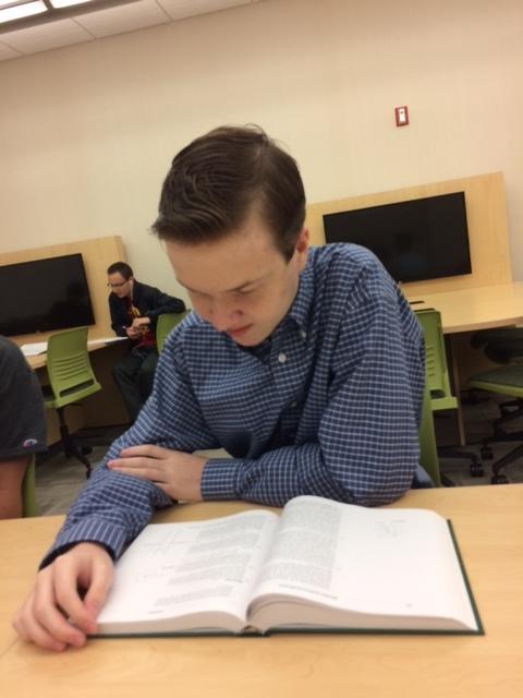 Practicing for the upcoming tryouts, Joey Heerens, club member and junior, studies his science textbook. Tryouts will be held on Sept. 13, from afterschool to 4:05 p.m. in room B214.