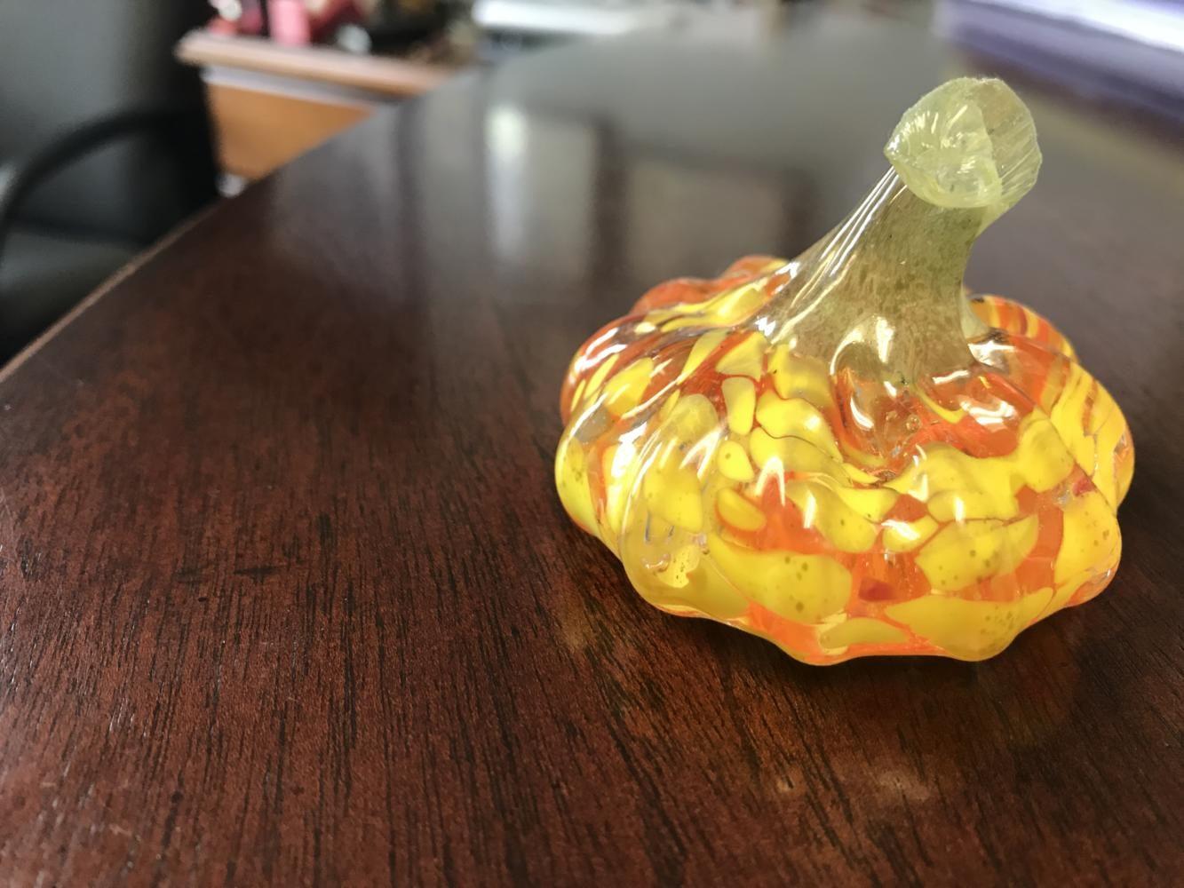 A glass pumpkin sits on a table in Heck’s office. The brightly-colored object was made by a hot glass artist that comes to the Arts and Design District during gallery walks on the second Saturday of the month in the fall and the spring.