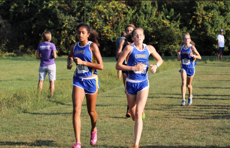 Junior Izza Khuram (1062) leads the pack at MIC Championship meet at Ben Davis High School on Sept. 23. Carmel finished in first place at the meet, continuing a streak that has lasted over a decade.