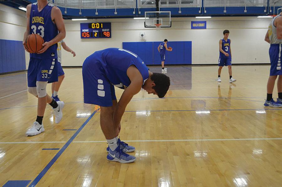 Luke Heady, varsity basketball player and junior, checks his socks during a practice. As a game ritual, Heady wears the same pair of socks during every game.