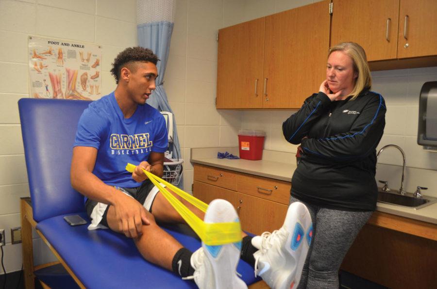 EXPERT HELP:
Athletic Trainer Anna Foster helps Eddie Gill, varsity basketball player and senior, in the training room. Foster said she likes helping athletes recover to pre-injury form. Agrayan Gupta | Photo