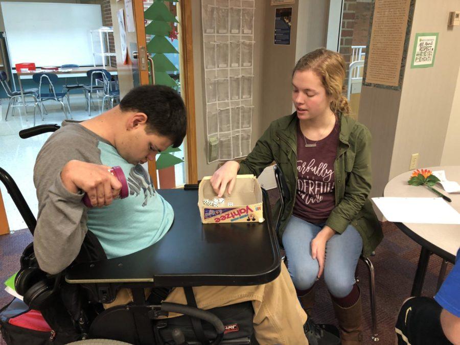 Best Buddies president Anne Schuh plays Yahtzee with a student with special needs. Anne spends her SRTs in D206, where she can spend time with peers with disabilities and aid Best Buddies sponsor Dana Lawrence. 