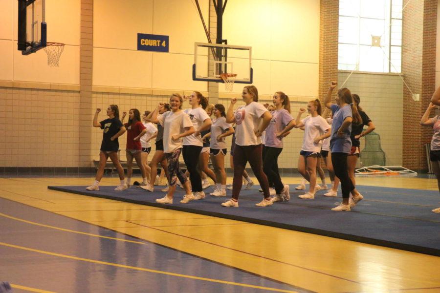 The Varsity Blue Cheer team reviews cheers they made the previous year and want to use again. The team practices two nights a week in the field house to prepare for their games. 