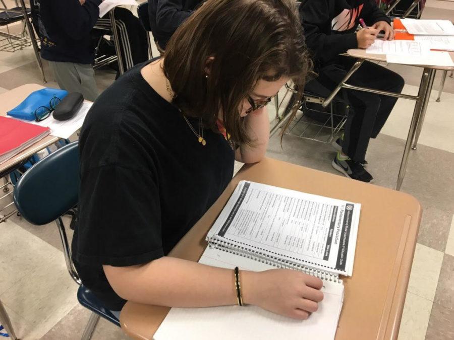 Model U.N. member and sophomore, Ava Hutchinson, looks over parliamentary procedure packet.