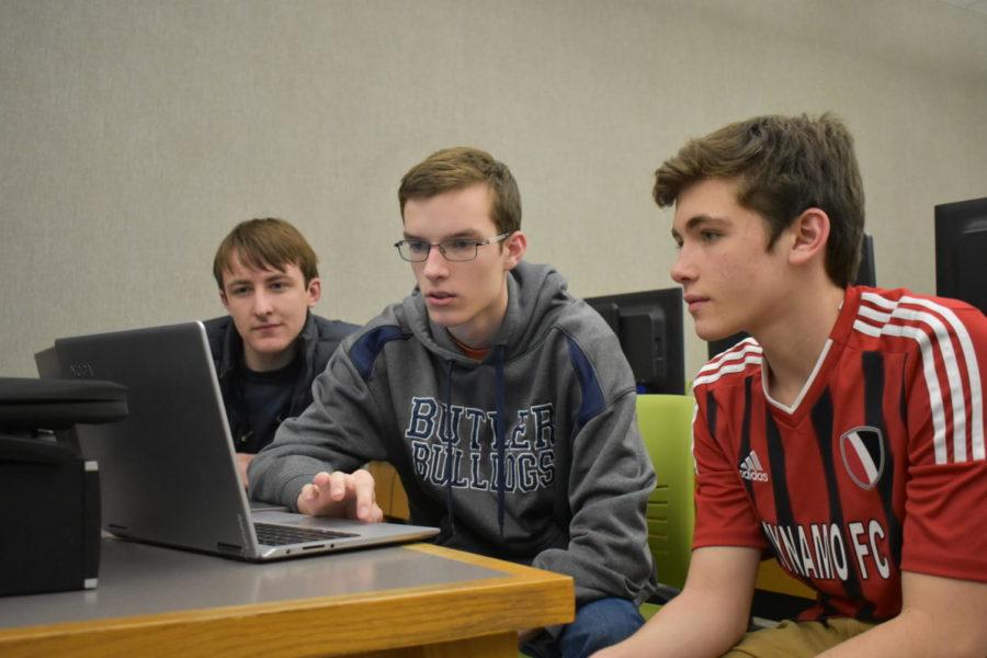 Jared Stigter (center), 
Code For Change Technology Lead and junior, helps Xavier Miller (left) and Sam Fang (right), club members and juniors, design a pricing page for the website.