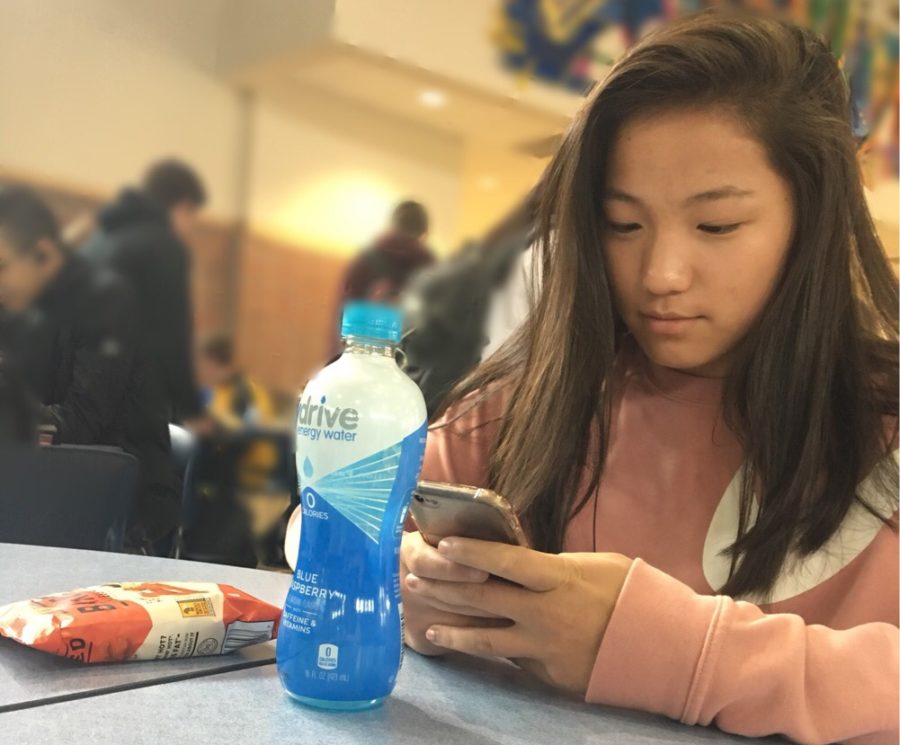 Ellie Backer, CDC soccer player and freshman, on her phone in the CHS lunchroom. She said she is excited for the upcoming CDC soccer season. “CDC makes playing soccer and exercising more fun without all the competitive stress,” Backer said.