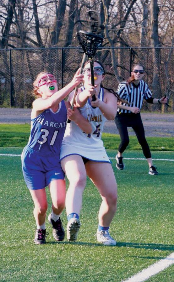 Victoria Simmons, lacrosse player and junior, fights for control of the ball. Athletes are able to better pick up the ball on turf fields. 