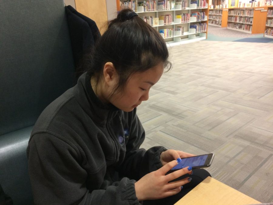 Senior Cassidy Jiang uses her phone during SRT to check her homework assignments on Canvas. She said starting school later would allow students’ brains to function better.
