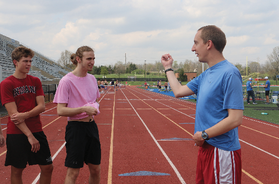 RUNNING HARD: Colin Altevogt, assistant coach for CHS track and head cross-country coach, helps runners analyze their form. Altevogt said both students and coaches use the off-season time to recover from injuries and prepare for the upcoming season.
