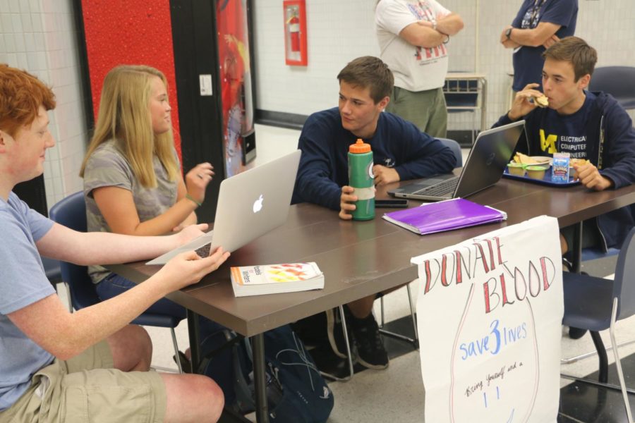 Caption: (left to right) Nathan Milam, Senate member and junior, Eva Brungard, Senate member and senior, Tim Metken, student body president and senior, and Peyton Sandlin, Senate member and junior, discuss sign-ups for the fall blood drive during lunch. Michelle Foutz, Senate sponsor and social studies teacher, said, There are surgeries scheduled in area hospitals around this blood drive, so were saving a lot of lives by doing this. Its one of the most important things that we do during the year.