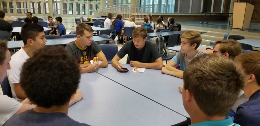 Thomas Gastineau, student leader and senior, leads a group in reading verses in the Bible. CRU Club sponsors decided to have club meetings more student run this year.