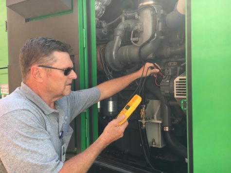 Maintenance worker Frederick “Fred” Sheats checks the alternator on a DC generator. This is one of the many jobs that he and the other maintenance staff do around the school on a regular basis.