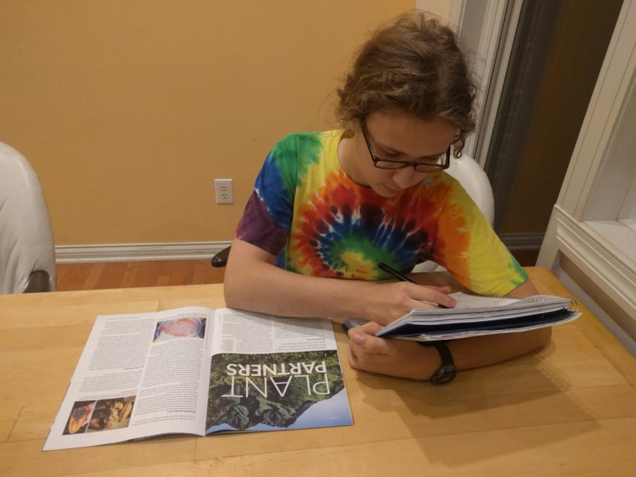 Kian Robinson, club member and junior, reads an article in a magazine about green initiatives.
