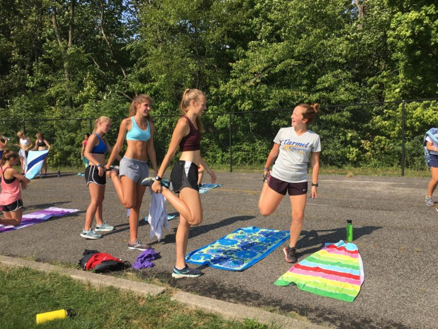 Senior runners of the women’s cross country team help start off stretches before a practice leading up to the MIC tournament. McCormack, pictured far right, is excited to see how the team will perform in their upcoming race.