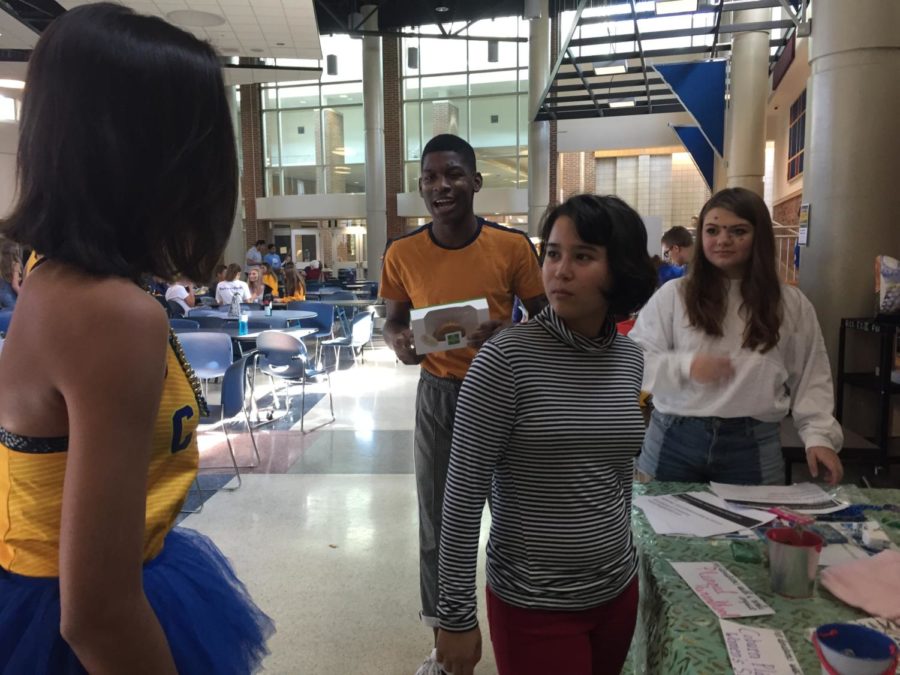 Teens with a Choice club members talk amongst themselves at the clubs Homecoming booth. The club sold baked goods and promoted the club in preparation for the upcoming year.