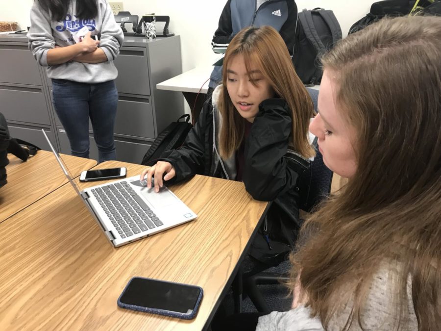  Senior Loraine Lee discusses potential roleplay categories with another DECA member. She said that she wants to help members find a roleplay that interests them because it will help motivate them to practice and do well. 
