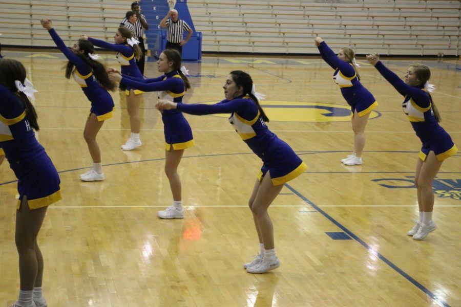 Winter Cheerleading team performs a cheer with various stunts at a womens basketball game. The cheerleaders performed this cheer during a time out to encourage the fans to cheer and because they were able to do stunts on the court. 