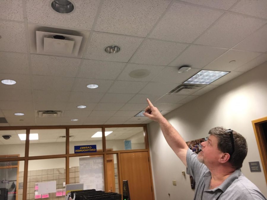 Maintenance worker Fred Napier points to a light in the activities office that went out earlier this week. This was one of many work orders that the maintenance staff has to look at on a daily basis.