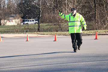A crossing guard halts a car at the intersection at the end of the trail. Sergeant D.J. Schoeff said pedestrian visibility is the school’s focus. 