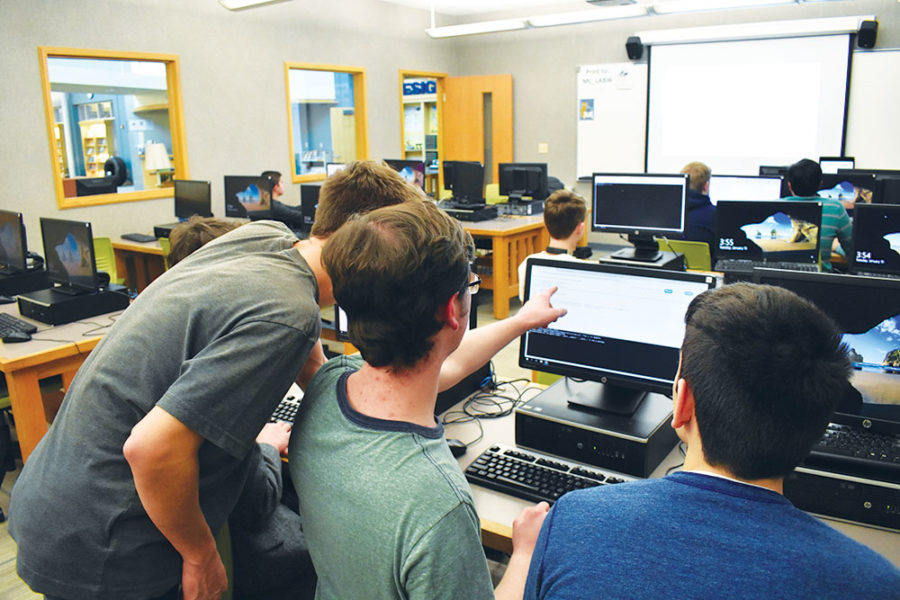 CODING CRACKDOWN:
Evan Kenyon (center) and Joseph Paavola (left), Code for Change officers and seniors, work together on code. The club meets after school on Tuesdays.