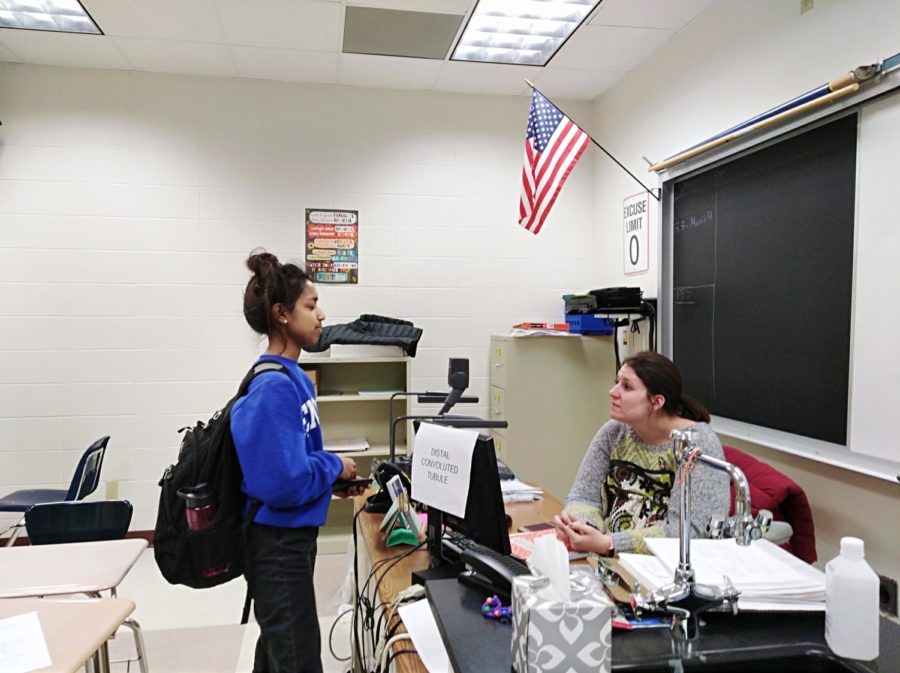 Sponsor and science teacher Alyssa Mastin talks with a senior Semanti Naiken about a Top Scholar nomination. Mastin said she often stays after school to talk with students or finish her work.  