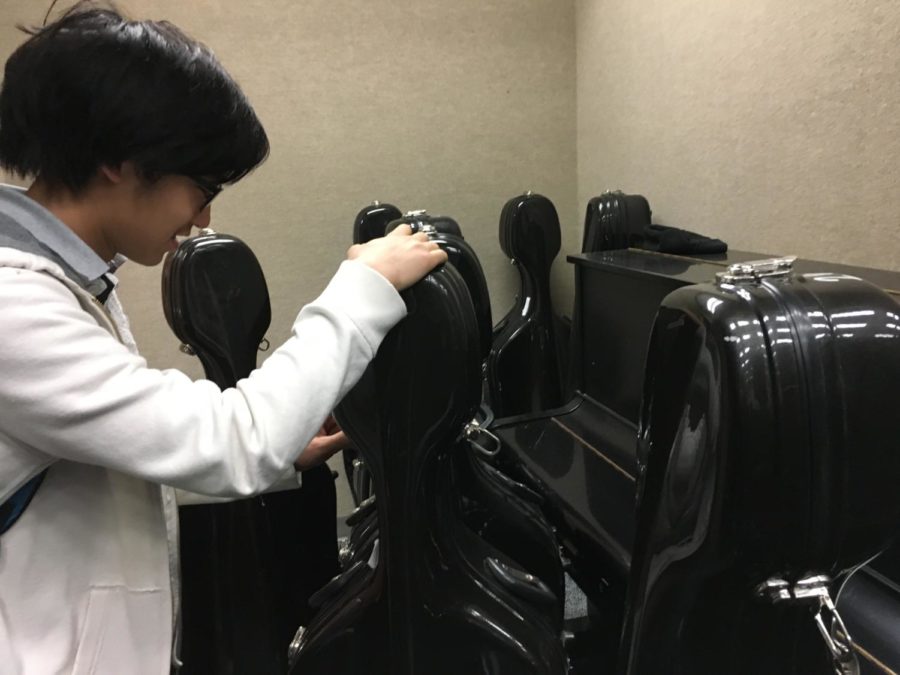 Noah Tan, member of Philharmonic Orchestra and sophomore, takes his
cello out of its case before after school rehearsal. He said the main
focus of his orchestra class for the past few weeks has been to
prepare their chamber music and contest music.