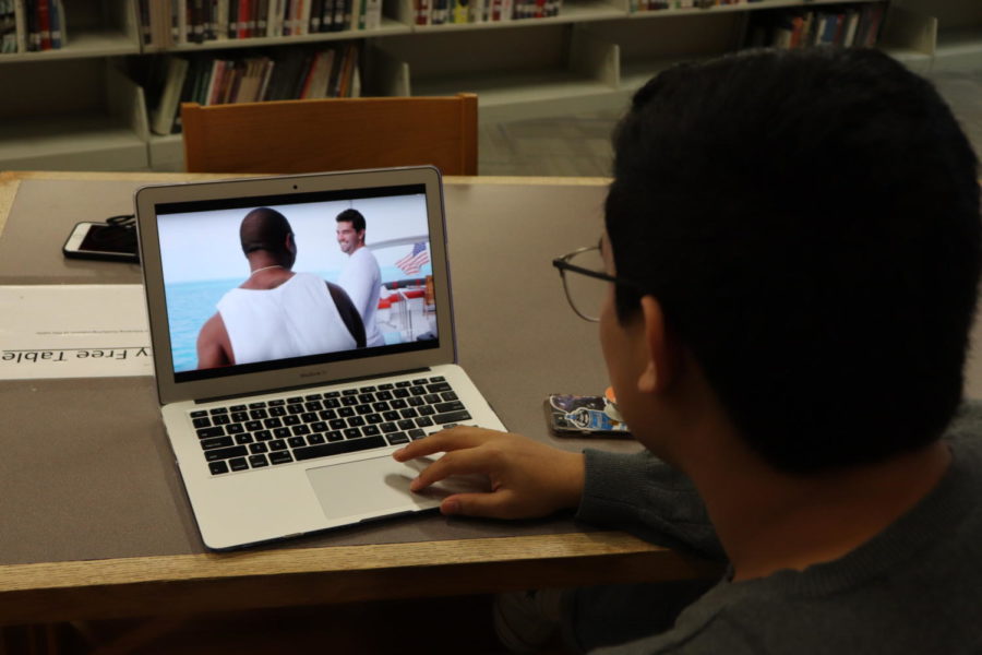 WATCH PARTY: Film lover and junior, Eshan Selvan, watches the trailer to Netflix’s “FYRE: The Greatest Party That Never Happened,” during his lunchtime in the library. Selvan said the new documentary had been recommended to him by many of his peers, and that he plans to watch it soon.