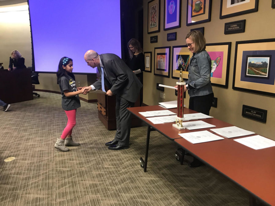 Superintendent Michael Beresford hands an award to a Science Bowl elementary school member during a school board meeting on Feb. 12. The award was intended to recognize the Collegewood Elementary School Science Bowl team for winning the Indiana state championship. 