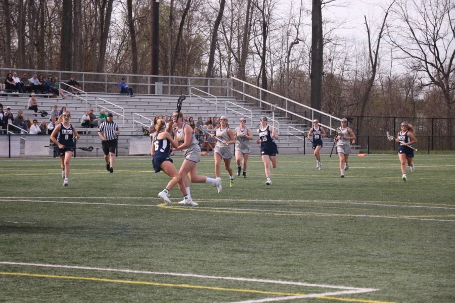 Mary Rose Ramsey, womens lacrosse player and senior, runs toward the goal with the ball as lacrosse team players follow. The team won against Cathedral 13-9.
