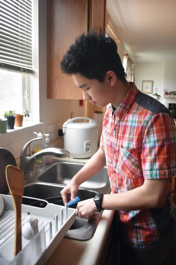 CLEAN-UP TIME: Senior Samuel Chen washes the dishes he used to cook lunch. Chen said he has become more independent over the past few years.