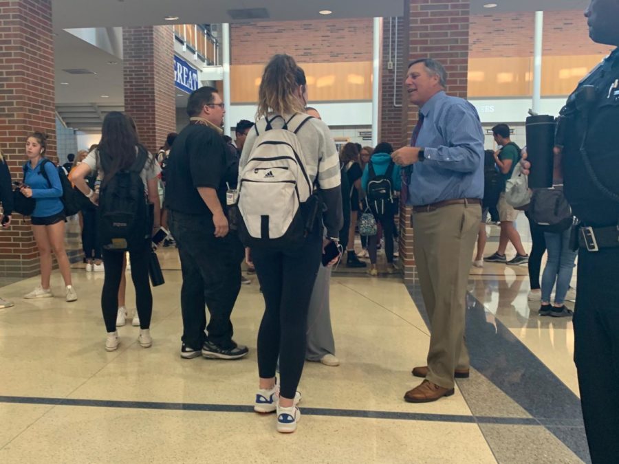 Principal Tom Harmas converses with students in the hallway during a passing period. He said hes excited to see all the homecoming changes in action and how the student body reacts to them.