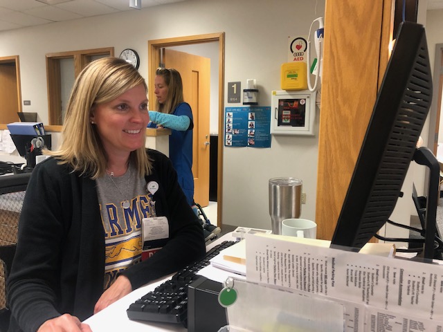RN Amy Fletchall reviews student immunizations on her desktop. Fletchall said the new policy is mandatory for the center to follow.