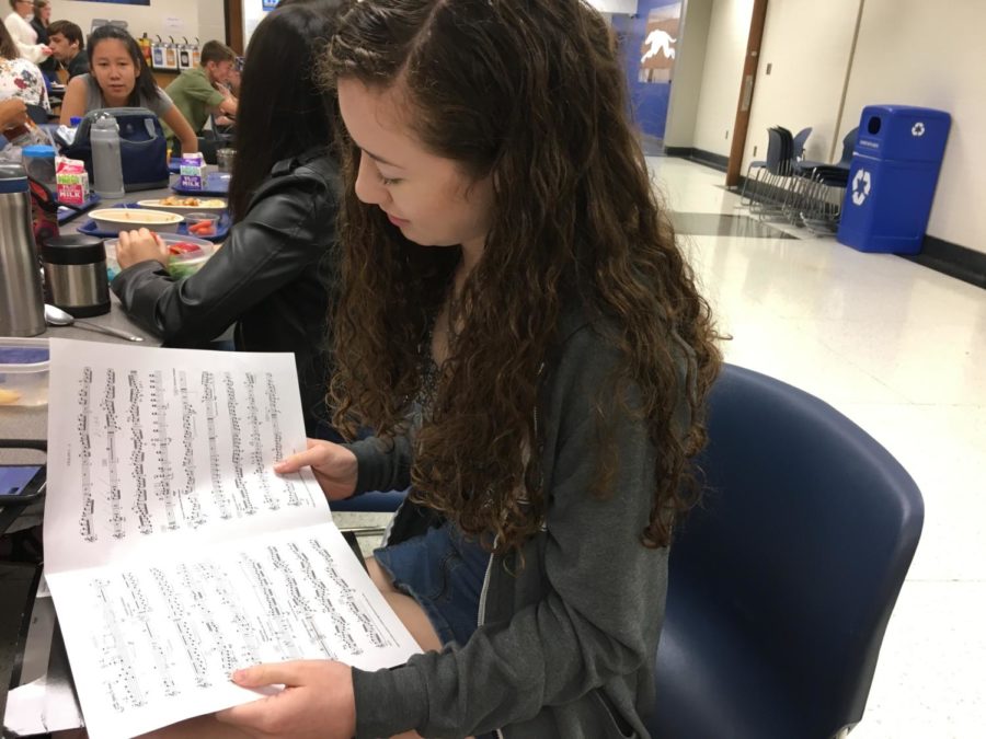 Olivia White, Philharmonic Orchestra member and junior, looks over her concert music. White said she has been recording herself practicing the music to keep track of her progress and use different practice techniques.
