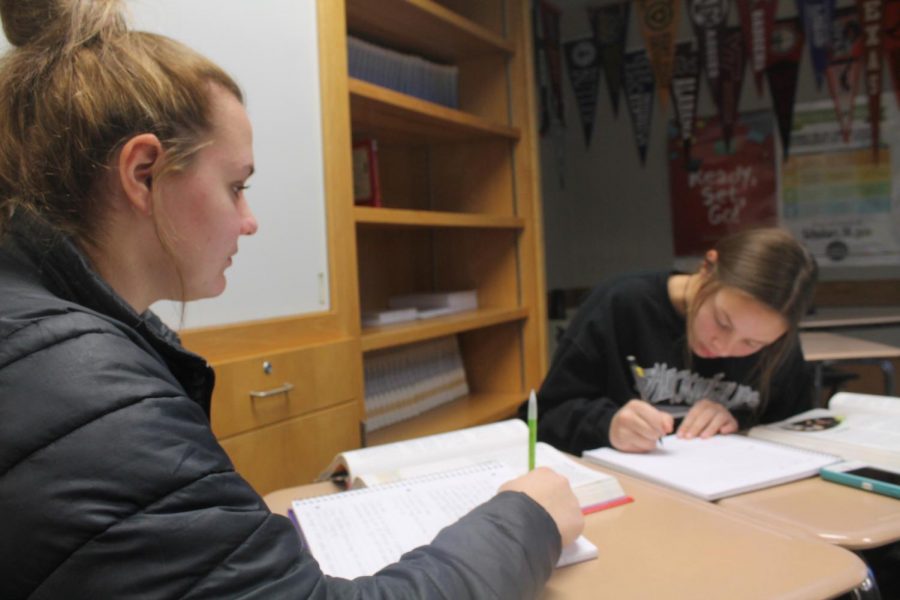 CHILD DEVELOPMENT: Sophomore Chloe Rogers and junior Lucy Timmons write down notes about child labor and birth during child development on Dec. 3. Students in child development often collaborate to share notes on what they found. It is a popular class for those who are interested in pursuing a degree in early education.