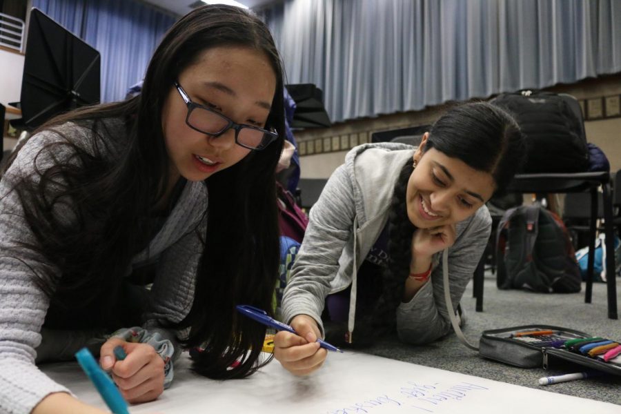 SHOW OFF: Freshmen Teresa Yu and Sneha Vashistha create a poster for the Orchestra Variety Show at the Orchestra Council meeting on Feb. 11. The Orchestra Council will host a variety show for orchestra students on March 6 from 6 to 9 p.m. Vashistha said, “(The meetings are) time to collaborate with friends and help out (the orchestra).”