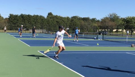 Varsity tennis player Presley Thenieman practices aggressive play for the State competition. He, along with the rest of the varsity team, won both of their matches at Sectionals.