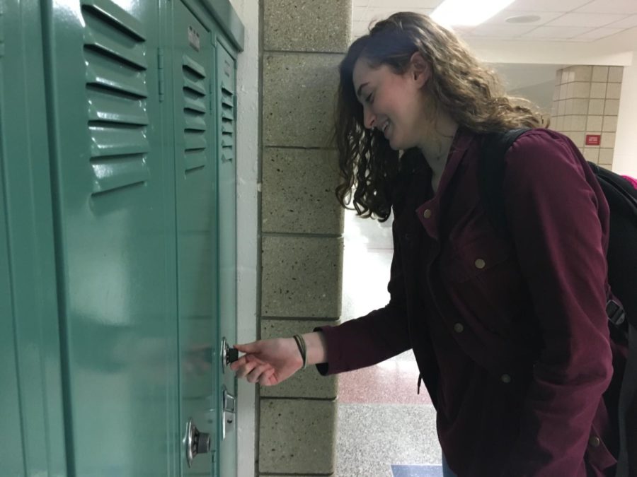 Sarah Konrad, Design Head and junior, tries to open her friend’s locker. Konrad said the speaker auditions have been postponed, and the club will decide on a new date soon.