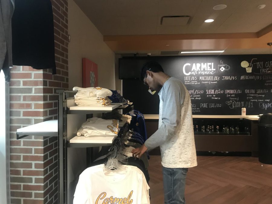 Senior Roshan Mahesh looks through merchandise in the Carmel Café during SRT. Mahesh said, The merchandise is a little expensive, but theyre produced by name brands like Nike so its worth the price.

