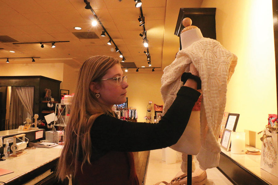SETTING UP
Senior Natalie Crispin sets up a clothing display at Francesca’s. Crispin said working on Black Friday was hard because she couldn’t take her time helping customers.	