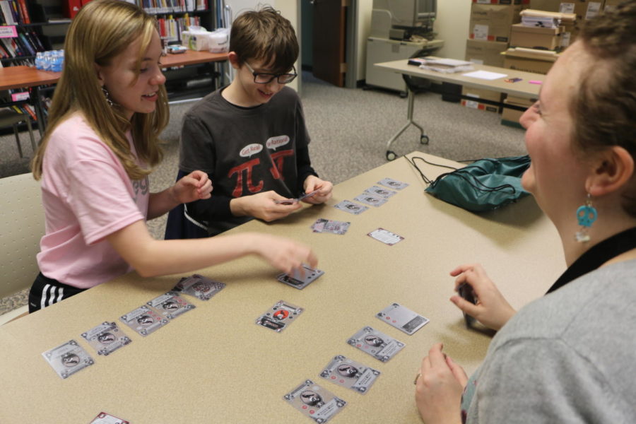 Junior Brooke Weisner and Sam Vrtismarsh play a card game with Young Adult Department Assistant Laura Swangin during Teen Writers’ Game Night on Nov. 5. This event, which was part of International Games Week, was combined with National Novel Writing Month to provide members of the community with collaborative storytelling integrated in games.