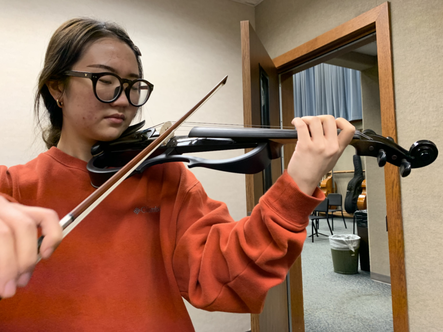 As+she+plays+the+electric+violin%2C+Jiwon+Yu%2C+the+Carmel+Electric+Ensemble%E2%80%99s+president+and+senior%2C+practices+the+music+she+will+play+at+the+ensemble%E2%80%99s+first+rehearsal.+The+ensemble+will+host+a+promotional+concert+in+the+commons+the+morning+of+Dec.+12.