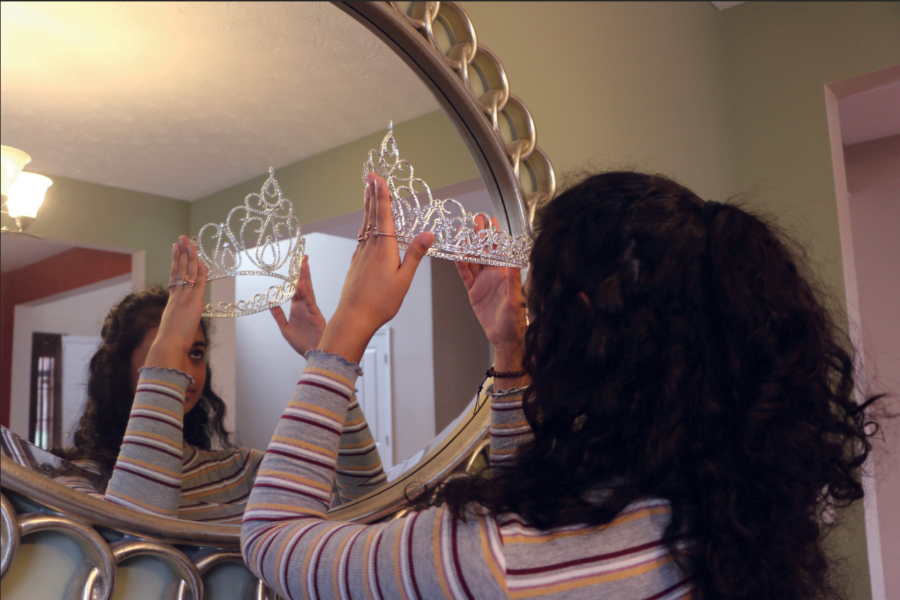 Abi Meyyappan, National American Miss Indiana (NAMI) finalist and senior, adjusts her tiara in a mirror. Meyyappan said she enjoyed her first beauty pageant experience.