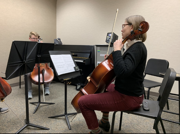 Elisabeth Ohly-Davis, director of orchestras, shows students how to play a song by demonstrating on the cello.