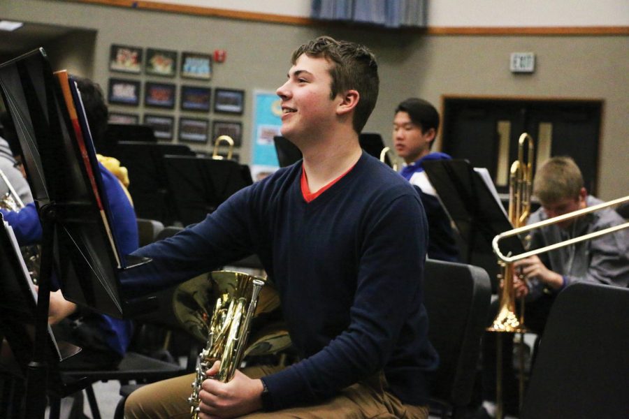 Junior Andrew (Andy) Schmidt plays around on his french horn during a break in Wind Symphony III. He said his favorite part of concert band is playing different types of music and the class helps him reenergize before the rest of his school day.