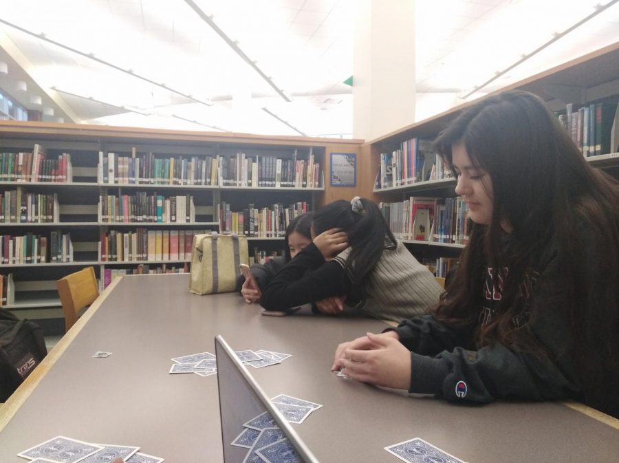 Alyssa Smith, senior and Wind Symphony I member, plays cards in the library during her release period. Smith said she is looking forward to performing at CBDNA.