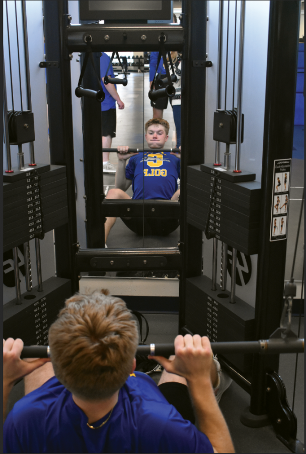 HEAVY LIFTING: 
Clay Stirsman, member of the men’s golf team and senior, lifts weights during pre-season practice. Stirsman said golf has evolved from being distance driven to having more emphasis on power and athletics to be more successful at certain skills. 