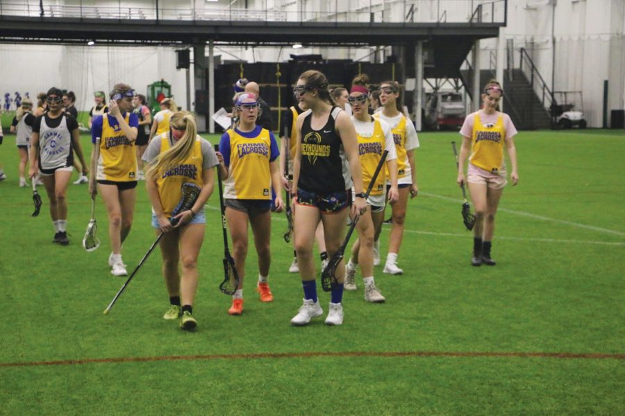 SISTERHOOD:
Caroline Ramsey, varsity lacrosse player and senior, walks off the field with her teammates. Ramsey, as well as swimming Head Coach Chris Plumb, said positive and uplifting team atmosphere motivates athletes to keep playing their sport. 