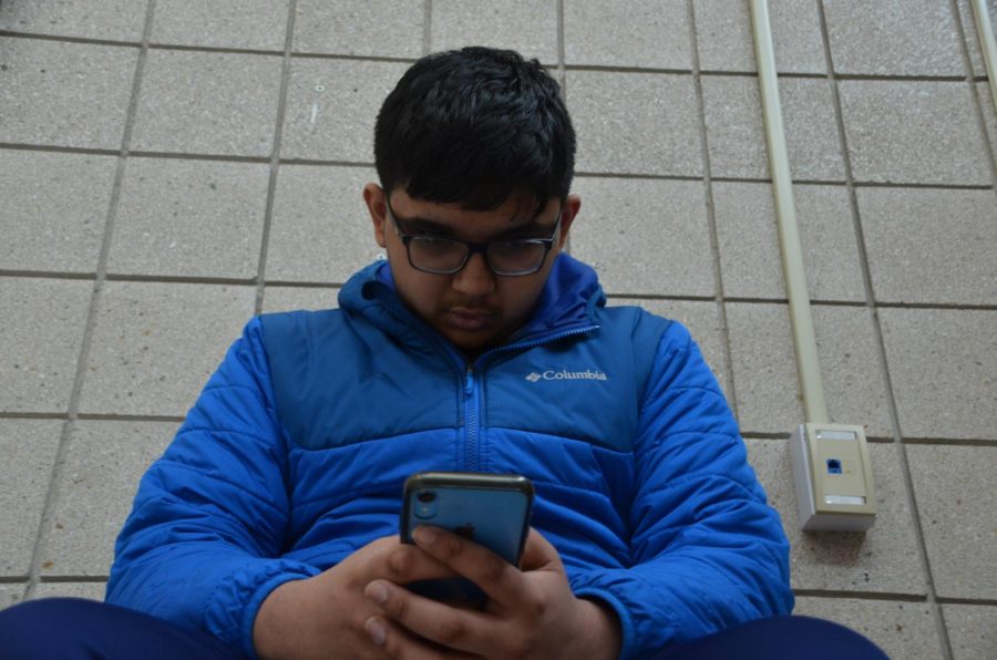 Sophomore Tanuj Mangalam scrolls through his phone. Mangalam said he views online dating for high school students as having more consequences than benefits.
