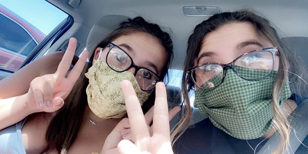 Juniors Averie and Faith Miner pose for a selfie together wearing personal protective equipment. Averie said she is happy her mom is working an online job which keeps her family safe. She said her family hopes to make the best out of the situation they are in. 