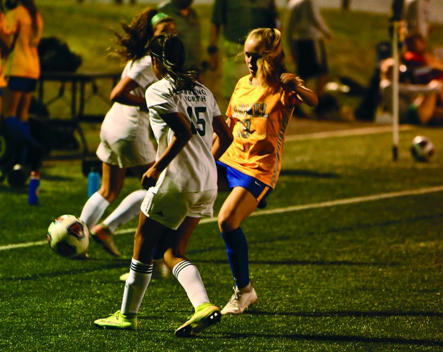 Lauren Rainbolt (right), varsity soccer player and junior, plays in the second half of her soccer game against Lawrence North high school on Sept. 8. Although Murray Stadium can only hold 250 people per IHSAA requirements, Rainbolt said she understands the precautions for keeping people safe. 